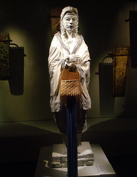 Young woman with basket sculpture - MC Snow. 